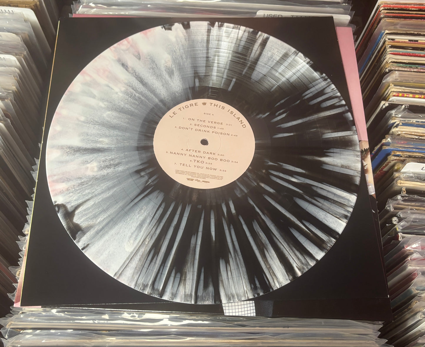 USED: Le Tigre - This Island LP record (black/blush w/ white splatter vinyl)
